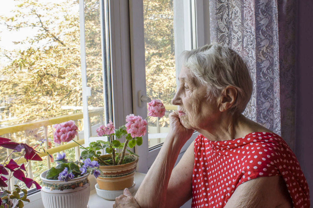 Elderly woman looking out a window