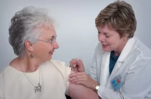 doctor giving an elderly woman an injection for her health